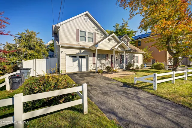 a view of a white house with a big yard and large trees