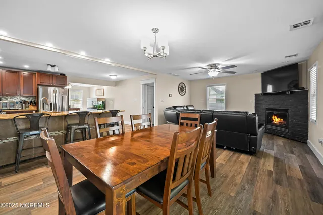 a dining room with furniture a fireplace and wooden floor