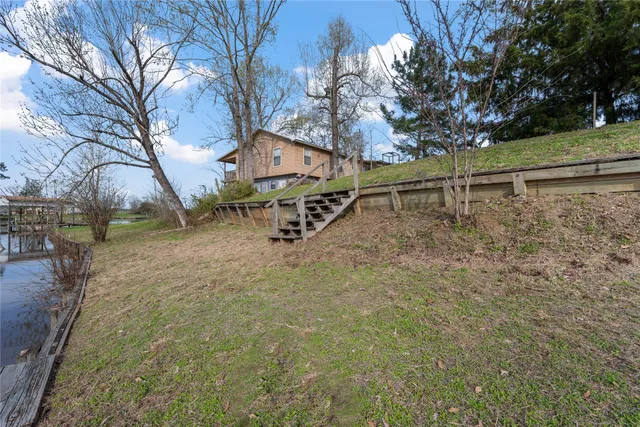 a view of a swimming pool with a patio and a yard
