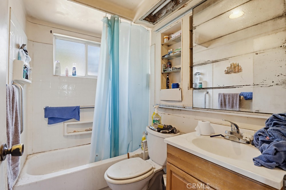 736 Sacramento Avenue Spring Valley, CA 91977 - Photo 17 of 33 a bathroom with a sink a toilet and shower curtain