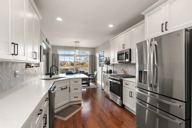a kitchen with stainless steel appliances a refrigerator sink and microwave