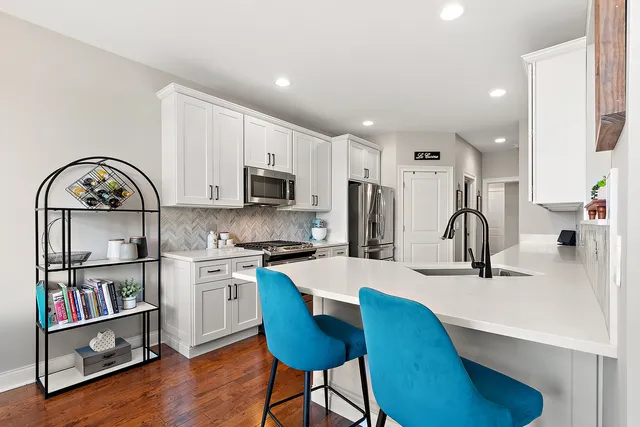 a kitchen with stainless steel appliances a sink cabinets and a wooden floor