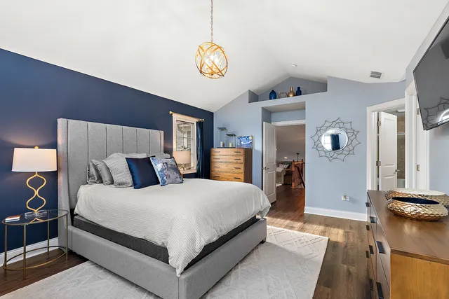 a bedroom with a bed and a chandelier