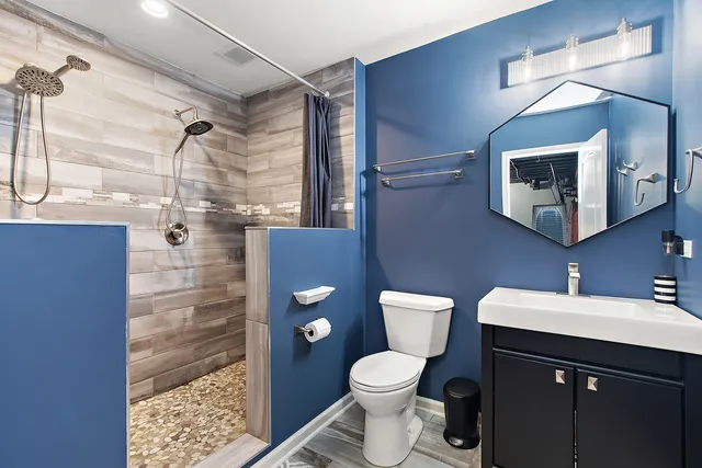 a bathroom with a sink vanity mirror and toilet