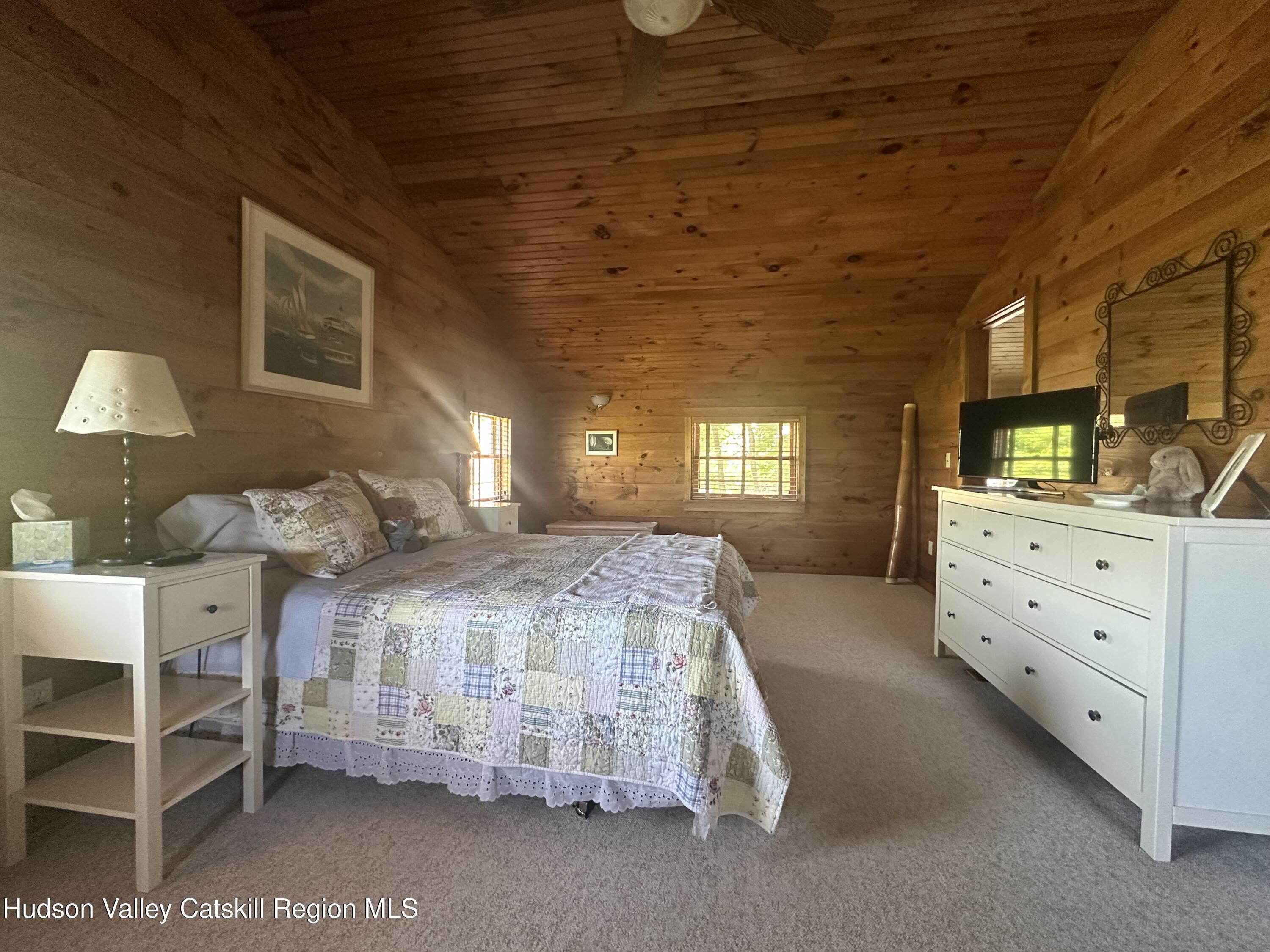 1492 County Road Copake, NY 12516 - Photo 14 of 34 a spacious bedroom with a bed and a window