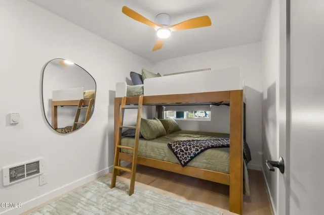 a bedroom with a bed and a mirror on the wall