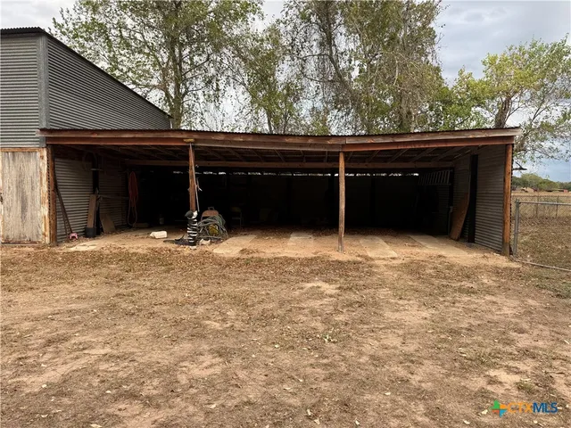 a view of a patio with table and chairs under an umbrella