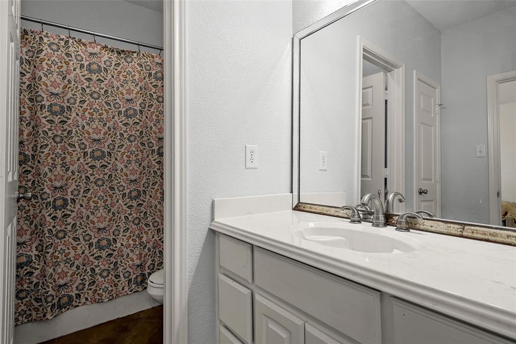 3696 Old Lorena Road Lorena, TX 76655 - Photo 20 of 27 Bathroom vanity featuring a white countertop with integrated sink, brushed nickel faucet, and a framed mirror