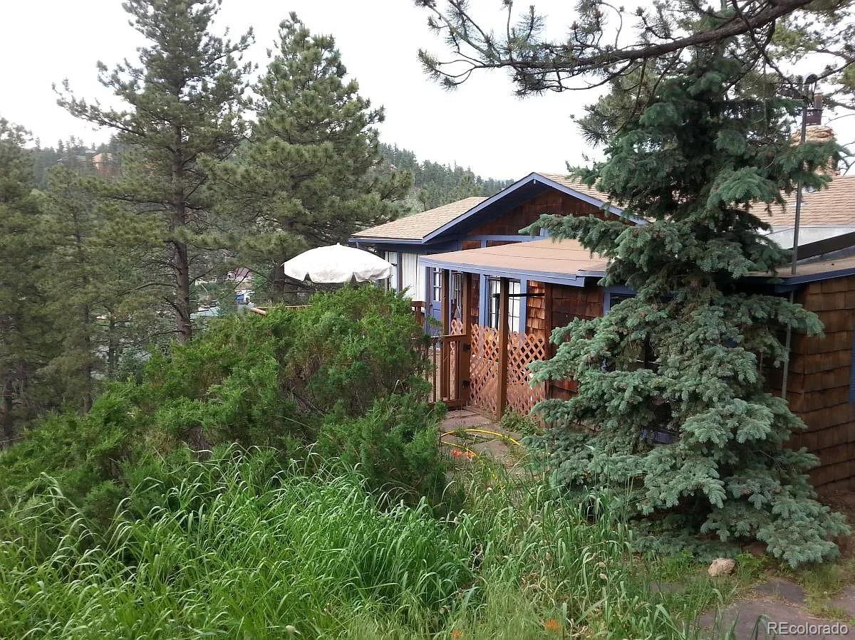 26079 Kingsbury Road Kittredge, CO 80457 - Photo 24 of 28 a front view of a house with a yard and garage