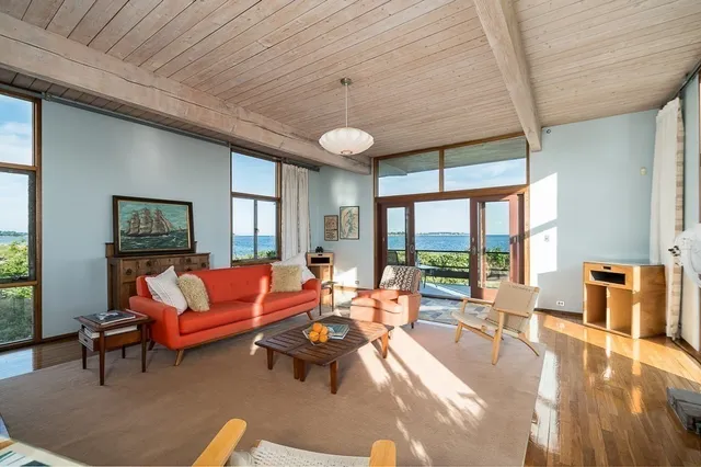 a living room with furniture a ceiling fan and a large window