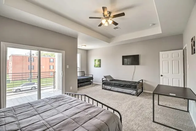 a spacious bedroom with a bed a couch and a chandelier