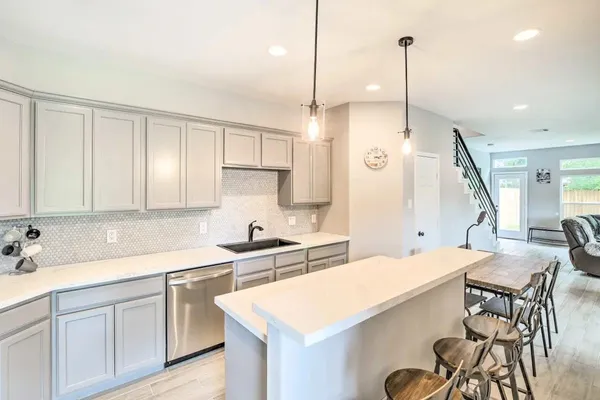 a kitchen with a sink a stove a center island and cabinets