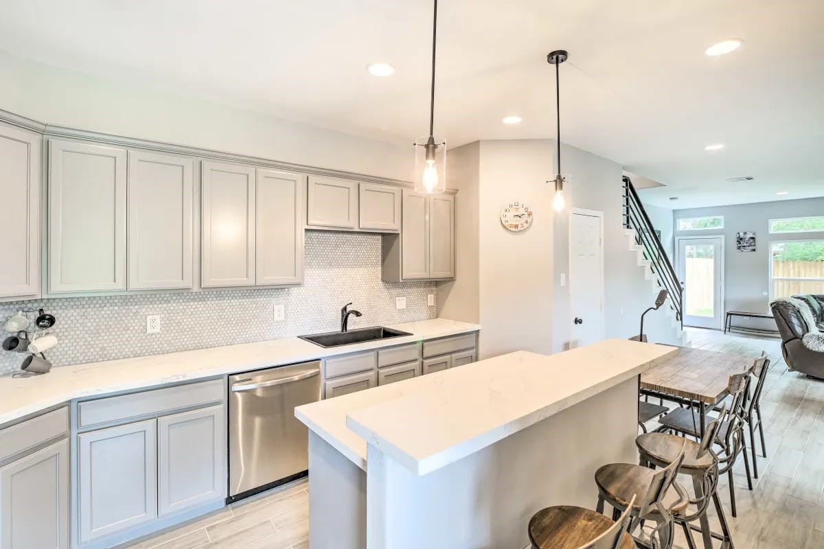4909 Sunflower Street Houston, TX 77033 - Photo 5 of 25 a kitchen with a sink a stove a center island and cabinets