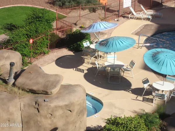 a view of a backyard with table and chairs under an umbrella