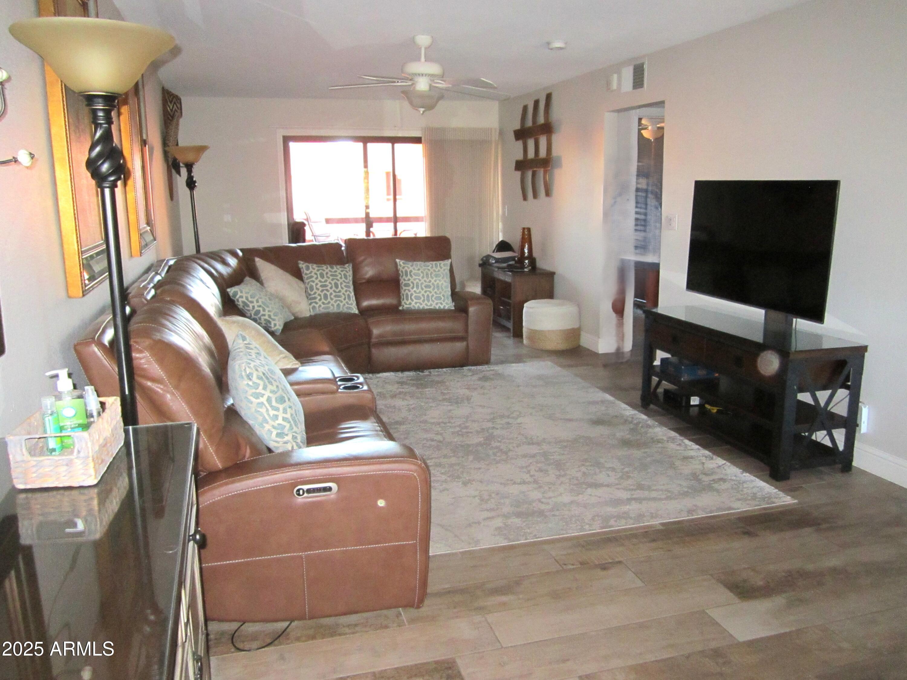 4303 East Cactus Road, Unit 407 Phoenix, AZ 85032 - Photo 2 of 16 a living room with furniture and a flat screen tv
