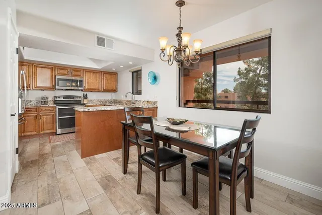 a view of a dining room with furniture a chandelier and wooden floor