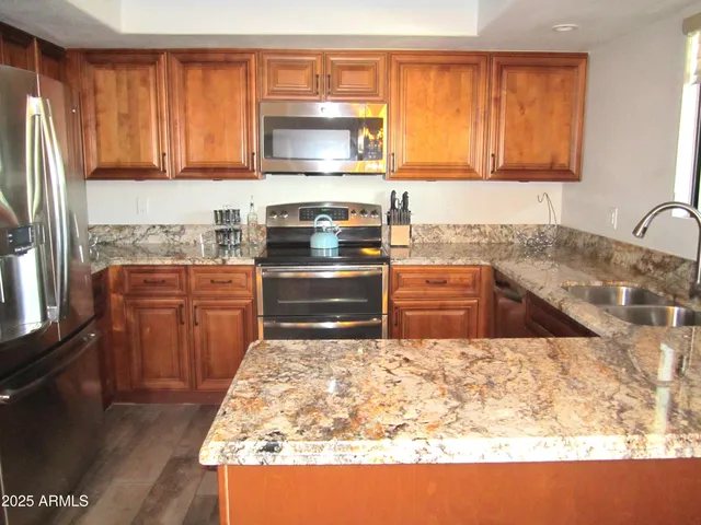 a kitchen with granite countertop a sink stove and microwave