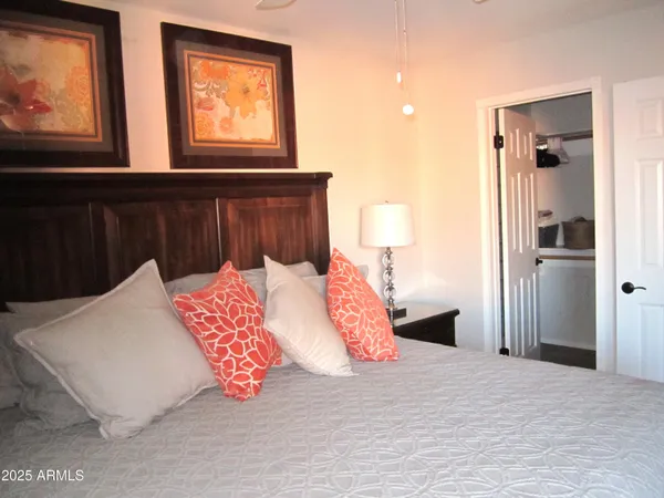 a bedroom with a bed and a painting on the wall