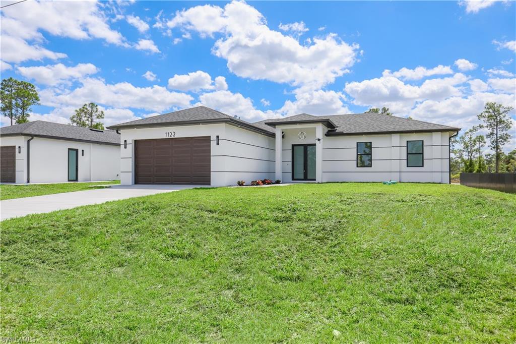 1122 Edelweiss Street East Lehigh Acres, FL 33974 - Photo 2 of 27 a front view of house with yard and green space
