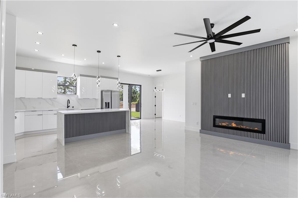 1122 Edelweiss Street East Lehigh Acres, FL 33974 - Photo 5 of 27 a living room with stainless steel appliances kitchen island a sink and a refrigerator