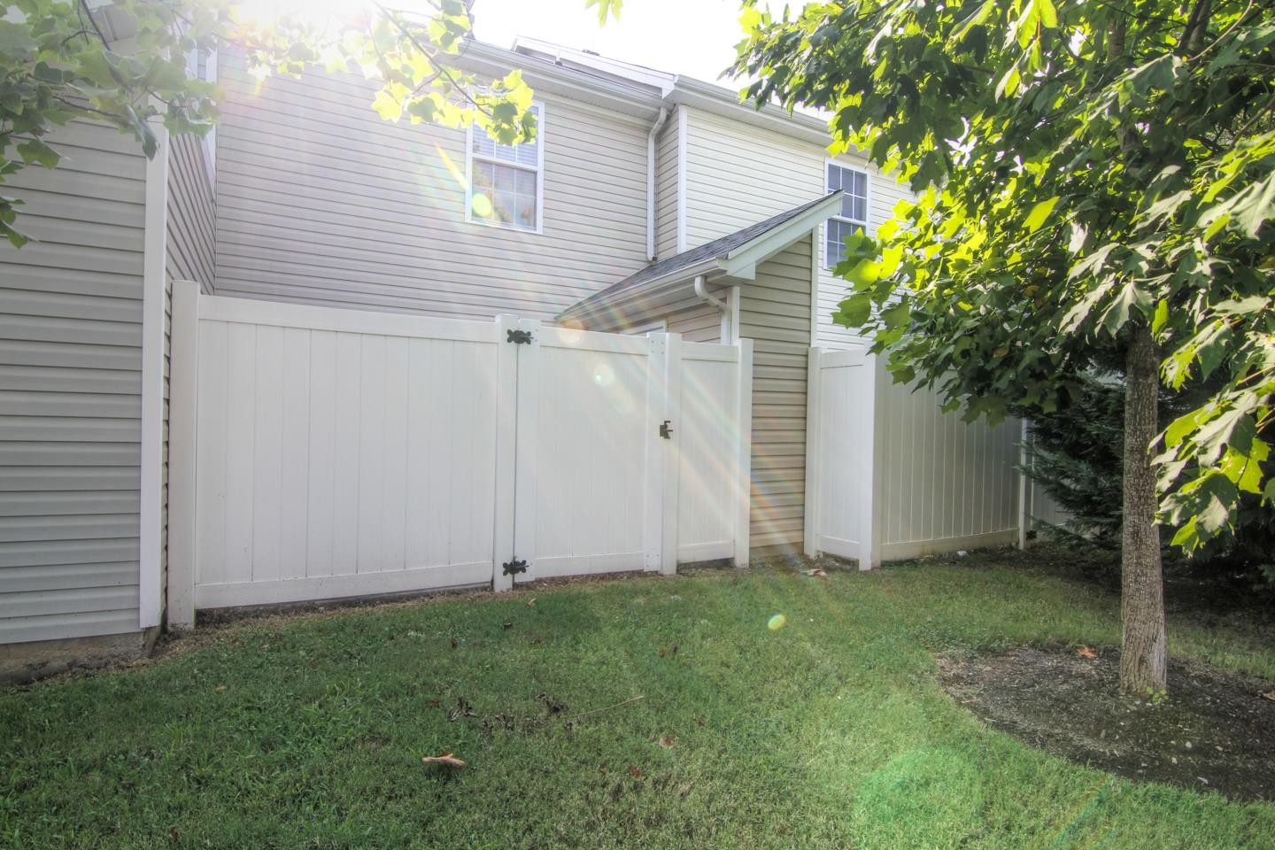 2961 South Rutherford Boulevard, Unit A4 Murfreesboro, TN 37130 - Photo 2 of 3 a view of a white house with a small yard and a large tree