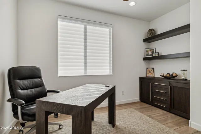 a view of a swimming pool with lawn chairs and large trees