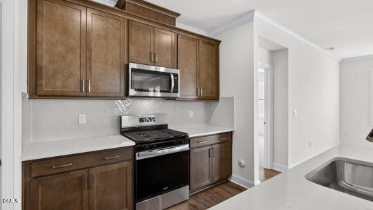 7580 Percussion Drive Apex, NC 27539 - Photo 12 of 44 a kitchen with stainless steel appliances granite countertop a sink stove and microwave