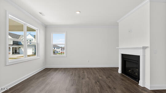 7580 Percussion Drive Apex, NC 27539 - Photo 17 of 44 an empty room with wooden floor fireplace and windows