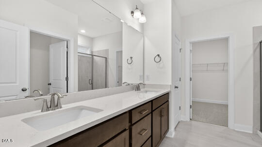 7580 Percussion Drive Apex, NC 27539 - Photo 32 of 44 a bathroom with a sink double vanity granite tub and a mirror