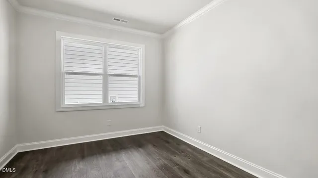 an empty room with wooden floor and a window