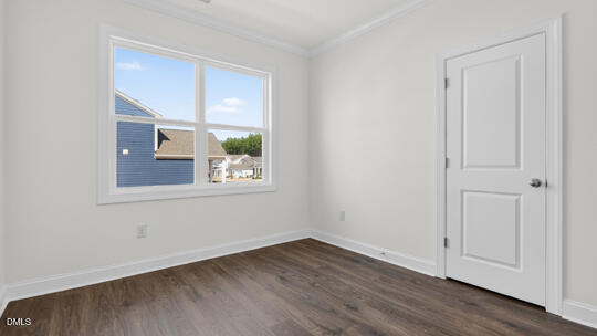 7580 Percussion Drive Apex, NC 27539 - Photo 7 of 44 a view of an empty room with wooden floor and a window