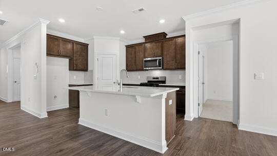 7580 Percussion Drive Apex, NC 27539 - Photo 8 of 44 a kitchen with stainless steel appliances a refrigerator stove microwave and cabinets