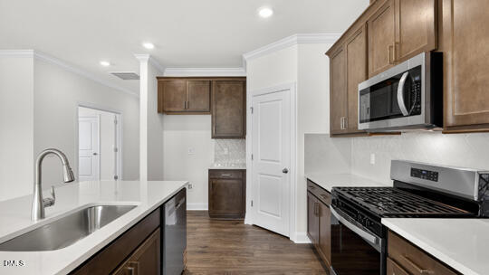 7580 Percussion Drive Apex, NC 27539 - Photo 10 of 44 a kitchen with stainless steel appliances granite countertop a stove a sink and a microwave