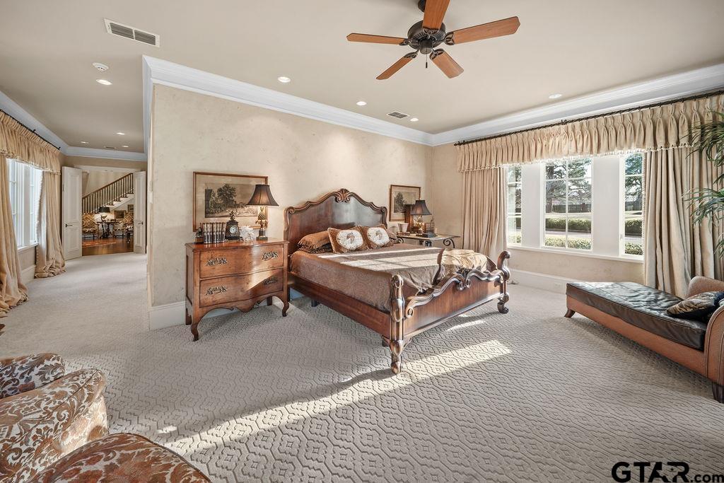 3048 Concord Place Tyler, TX 75701 - Photo 16 of 34 a spacious bedroom with a bed a couch and a chandelier