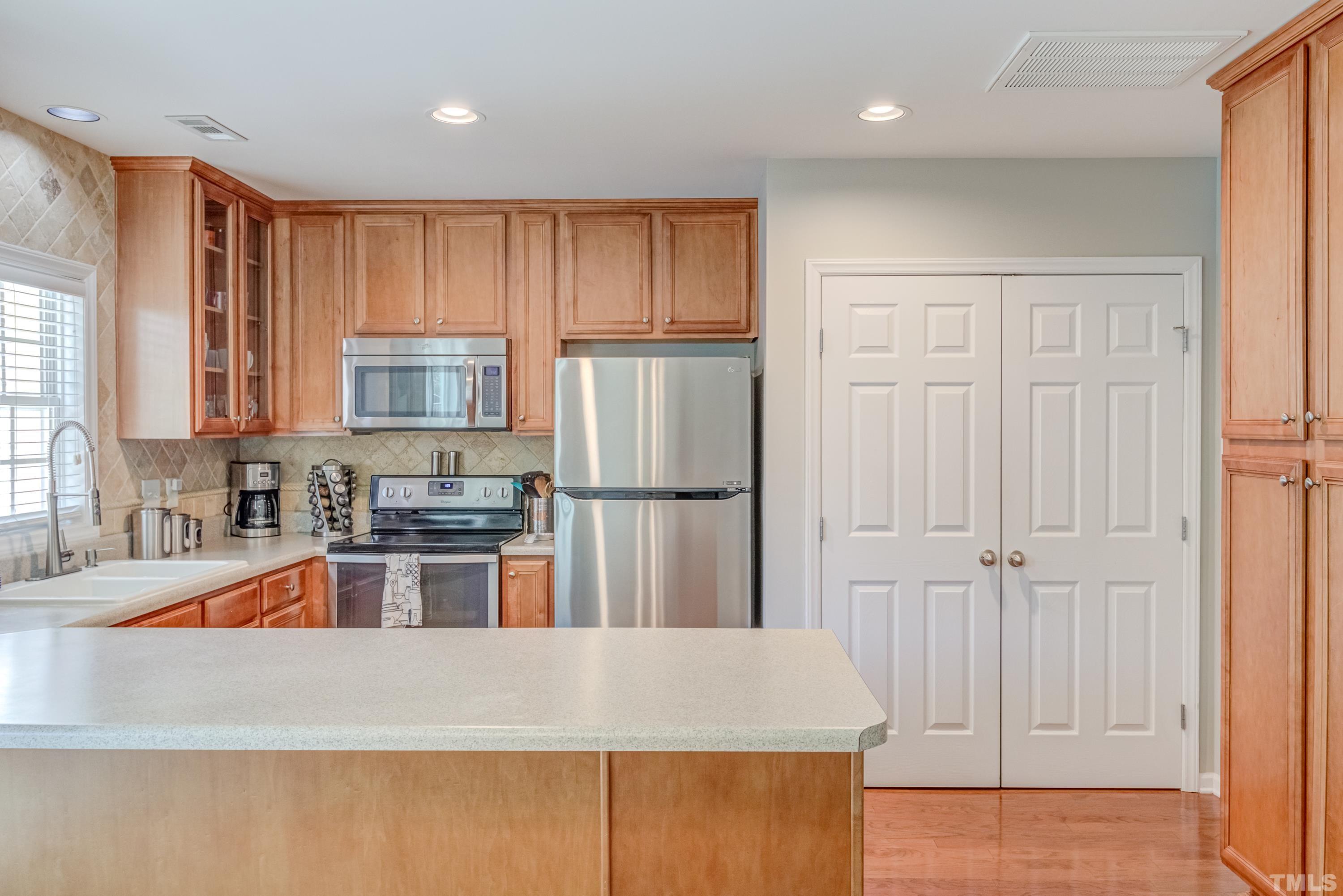 2101 Piney Brook Road, Unit 107 Raleigh, NC 27614 - Photo 13 of 37 a kitchen with stainless steel appliances granite countertop a refrigerator sink and stove