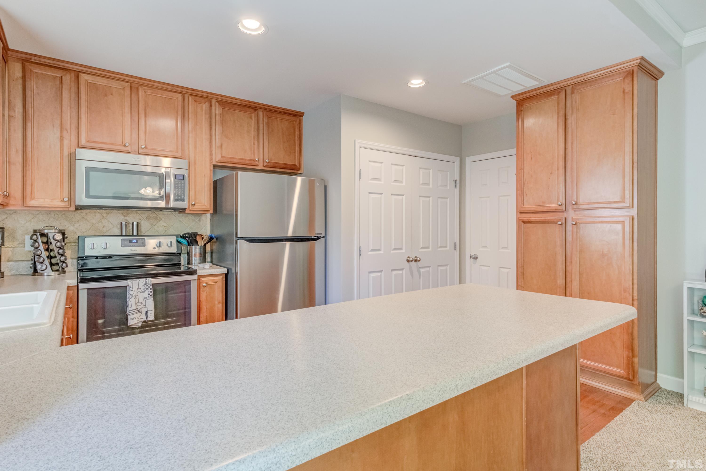 2101 Piney Brook Road, Unit 107 Raleigh, NC 27614 - Photo 14 of 37 a kitchen with kitchen island a counter top space stainless steel appliances and cabinets