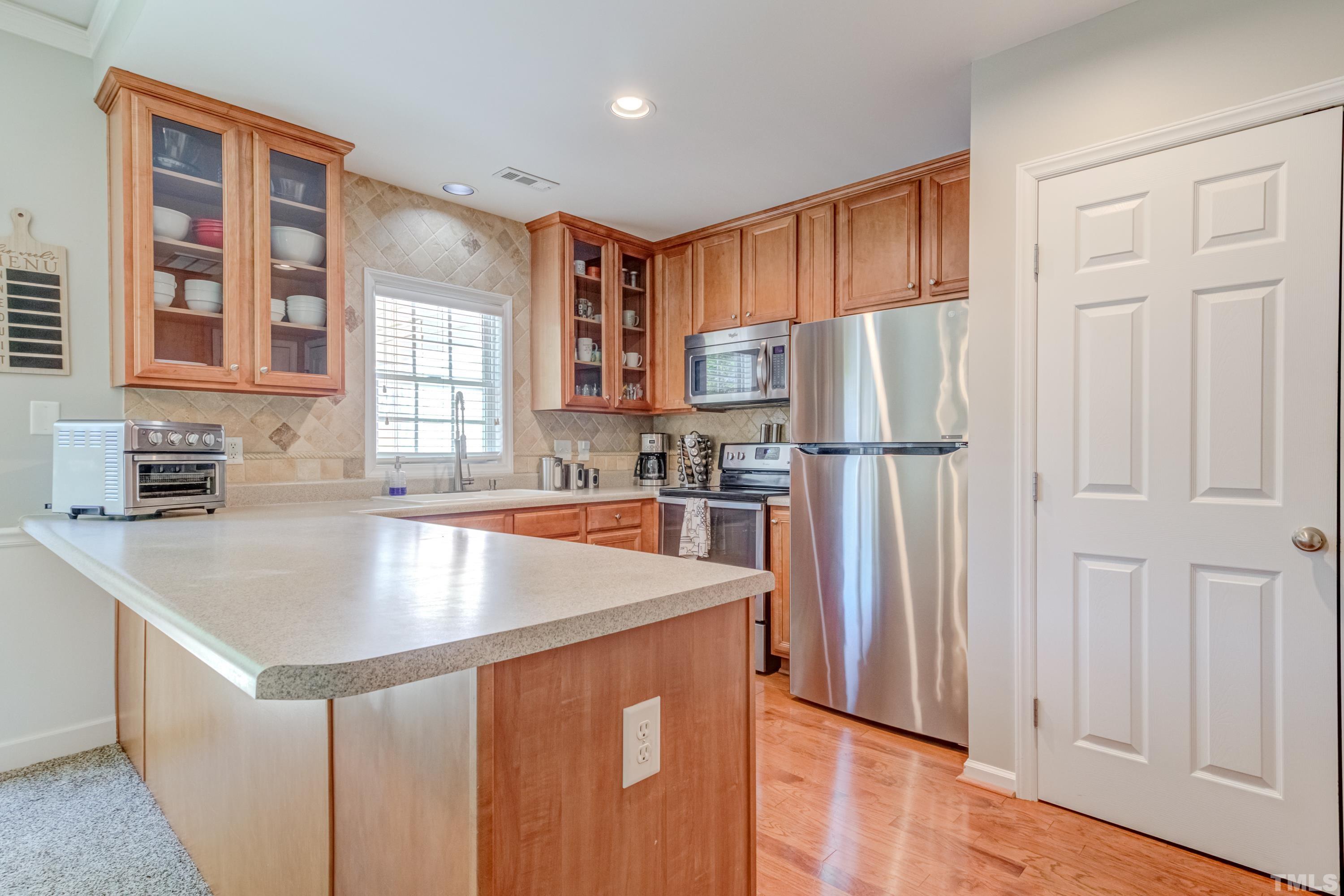 2101 Piney Brook Road, Unit 107 Raleigh, NC 27614 - Photo 15 of 37 a kitchen with stainless steel appliances granite countertop a refrigerator a sink dishwasher a stove and a refrigerator with wooden floor