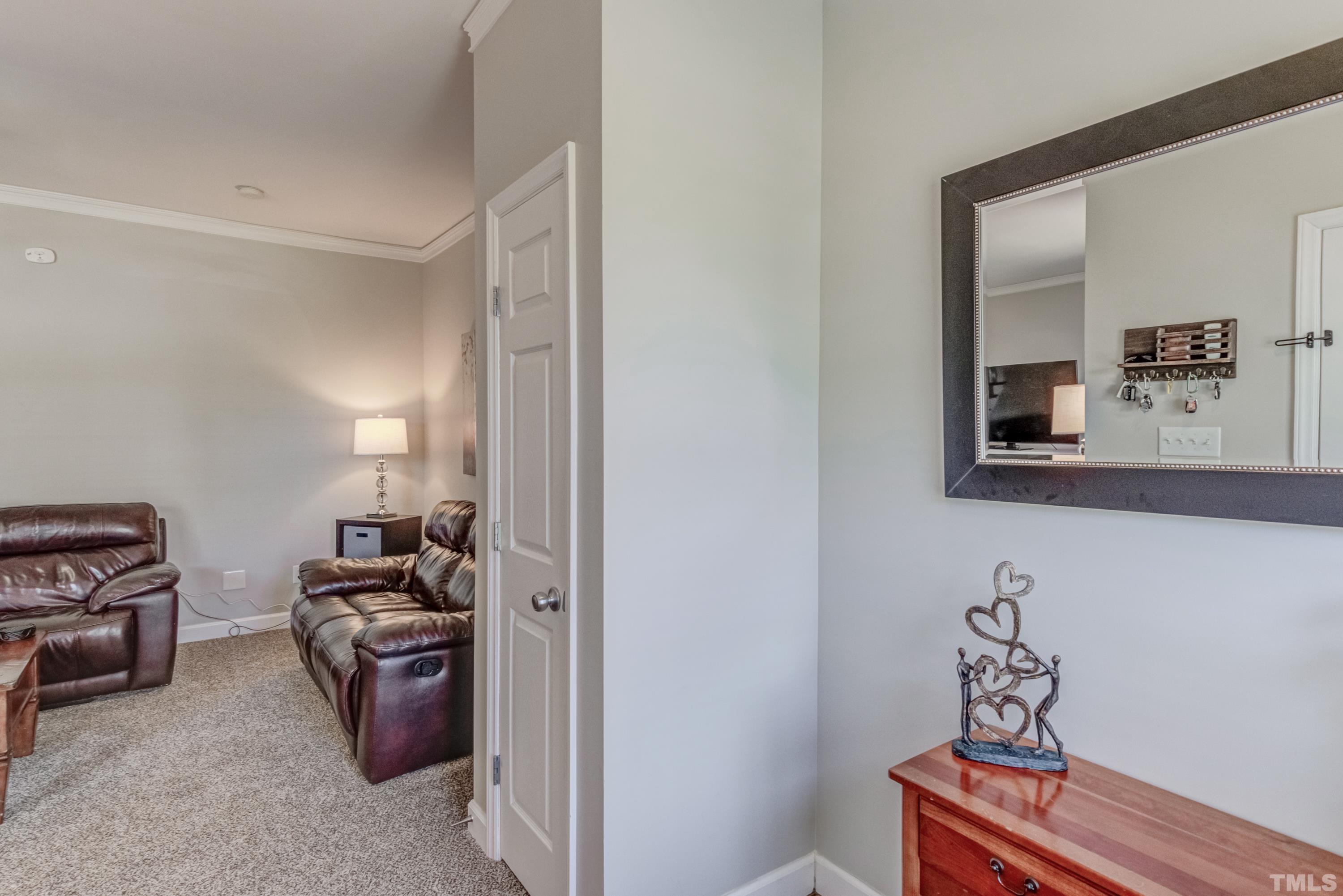 2101 Piney Brook Road, Unit 107 Raleigh, NC 27614 - Photo 4 of 37 a room with furniture a mirror and a wooden floor