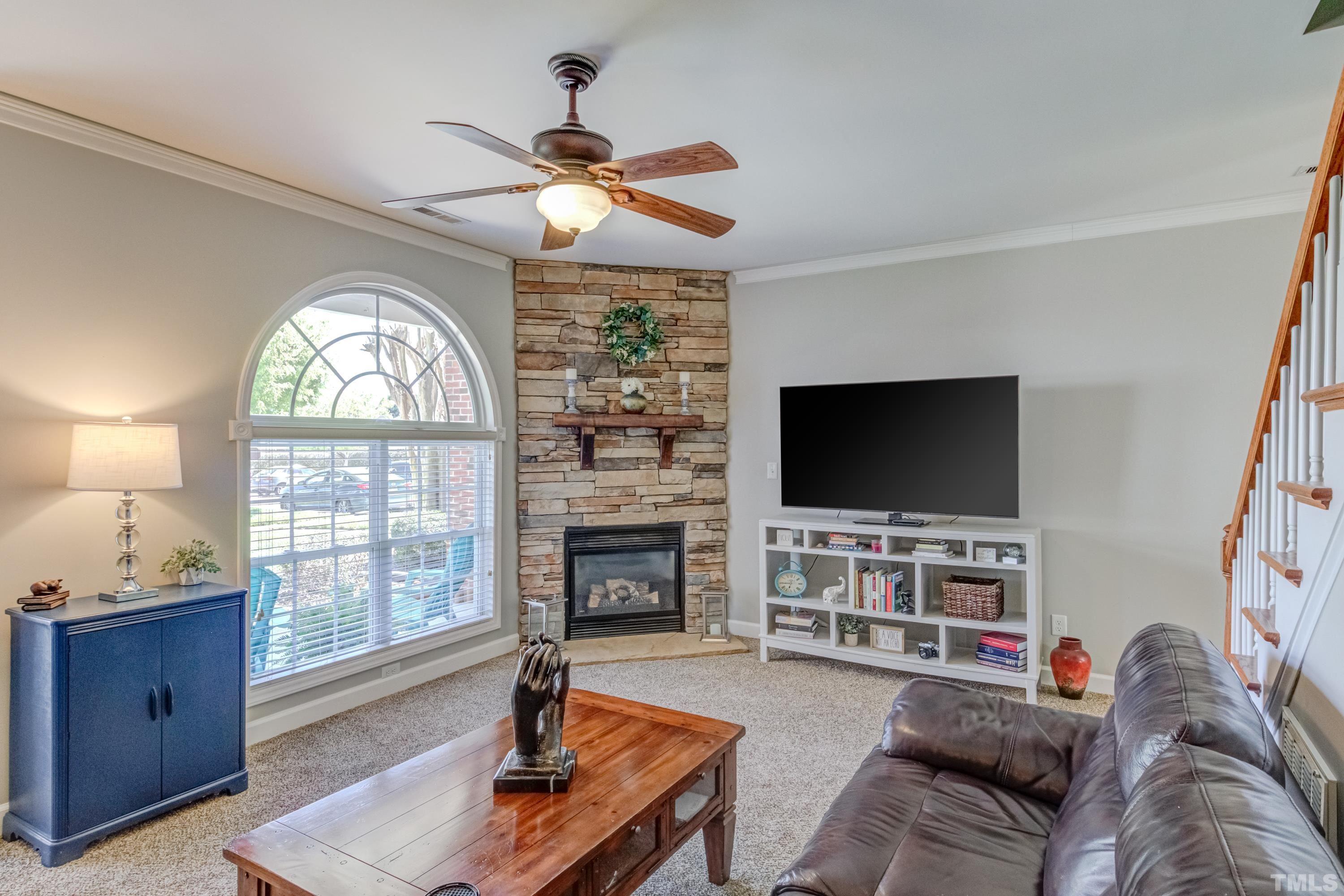 2101 Piney Brook Road, Unit 107 Raleigh, NC 27614 - Photo 6 of 37 a living room with furniture a flat screen tv and a fireplace