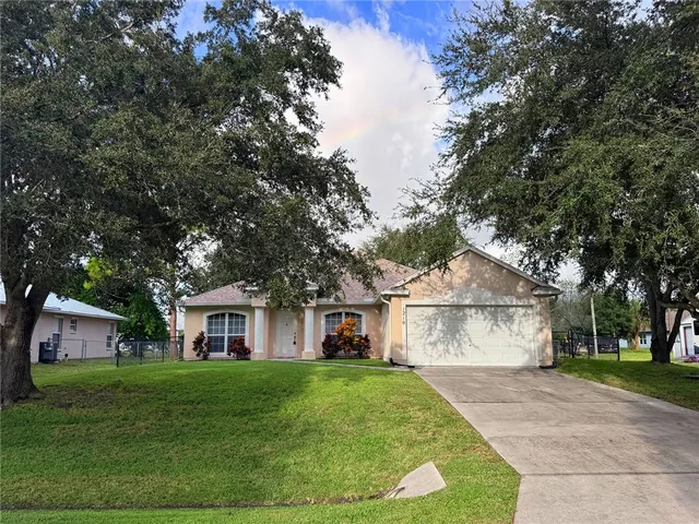 a front view of a house with a yard and trees