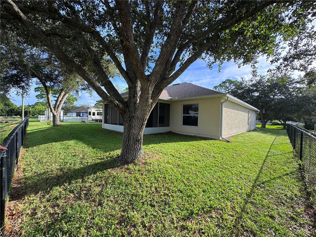 1210 Clearmont Street Sebastian, FL 32958 - Photo 28 of 31 a view of a house with a tree in the yard