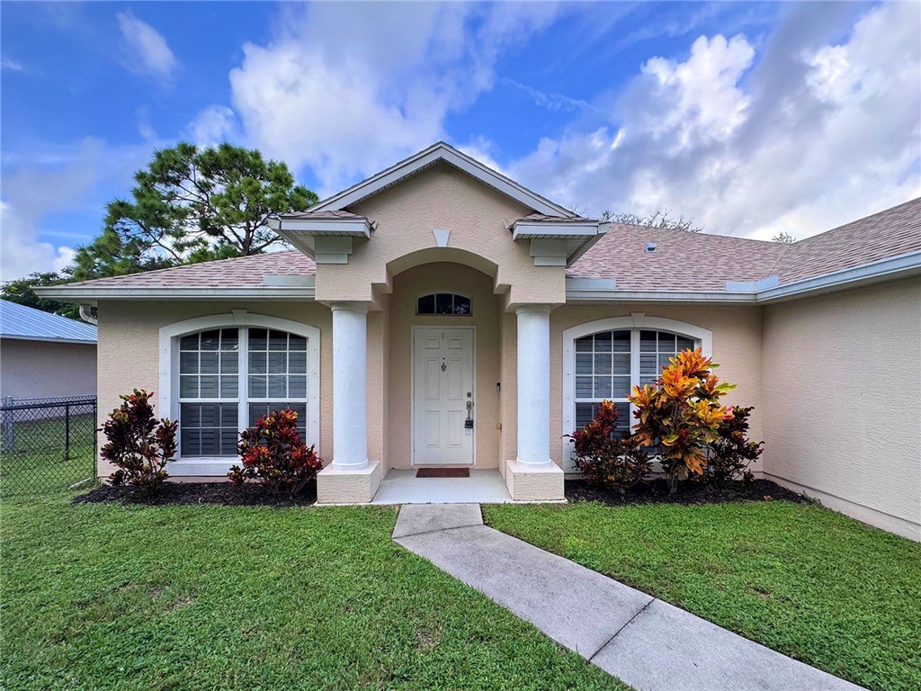1210 Clearmont Street Sebastian, FL 32958 - Photo 30 of 31 a front view of a house with a garden and plants
