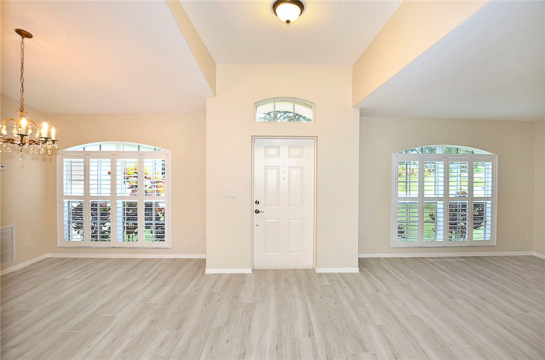 1210 Clearmont Street Sebastian, FL 32958 - Photo 4 of 31 an empty room with wooden floor and windows