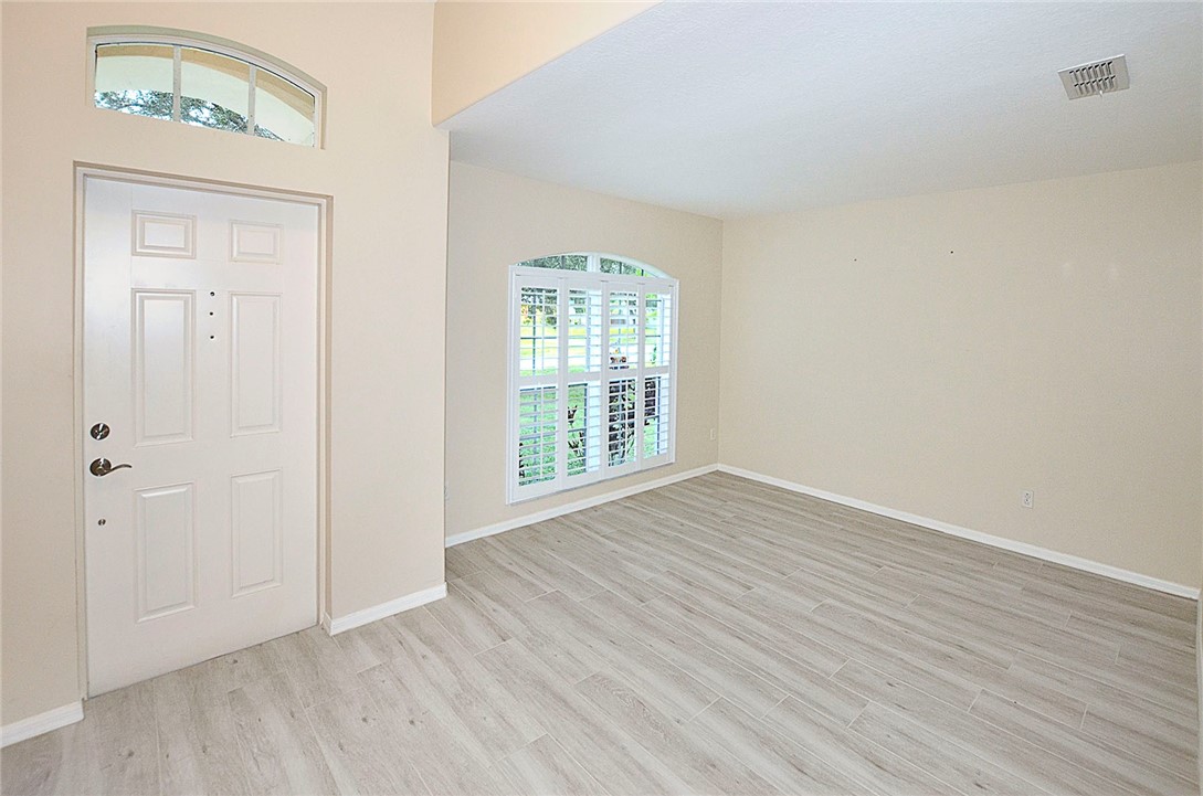 1210 Clearmont Street Sebastian, FL 32958 - Photo 6 of 31 a view of an empty room with wooden floor and a window