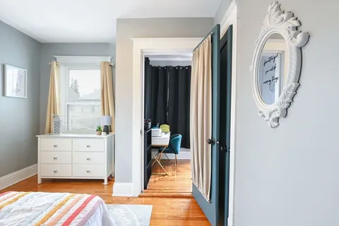 a view of a hallway with entryway wooden floor and windows