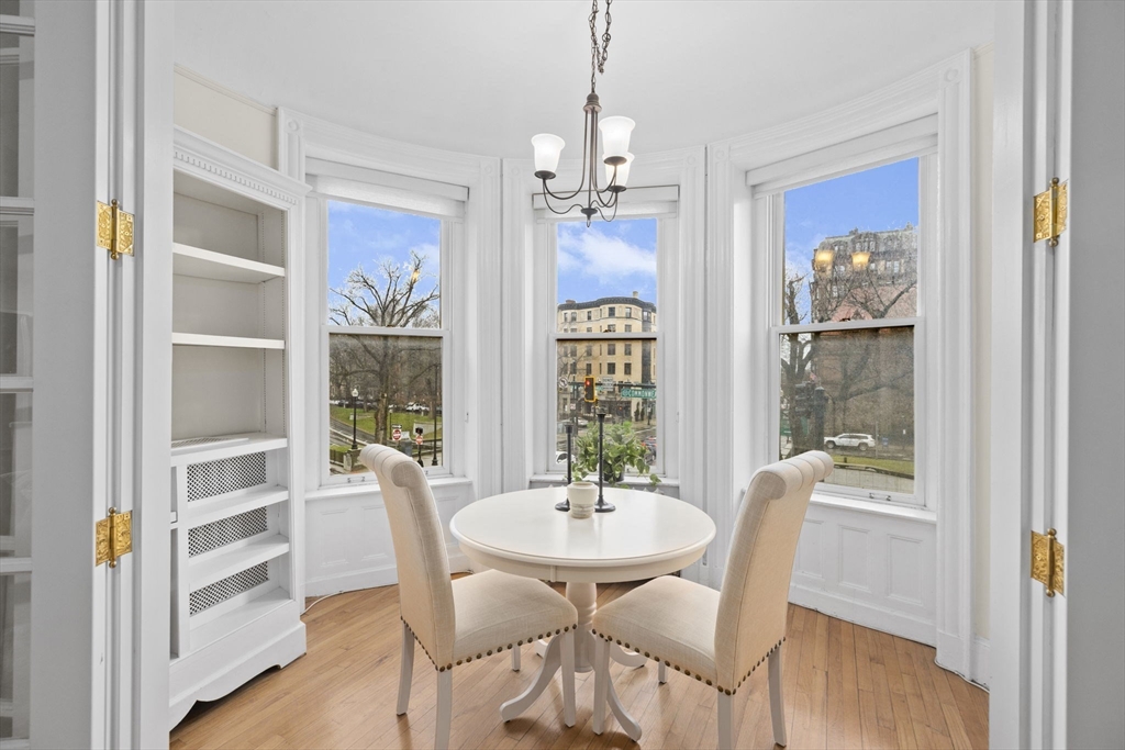 a dining room with furniture a chandelier and wooden floor