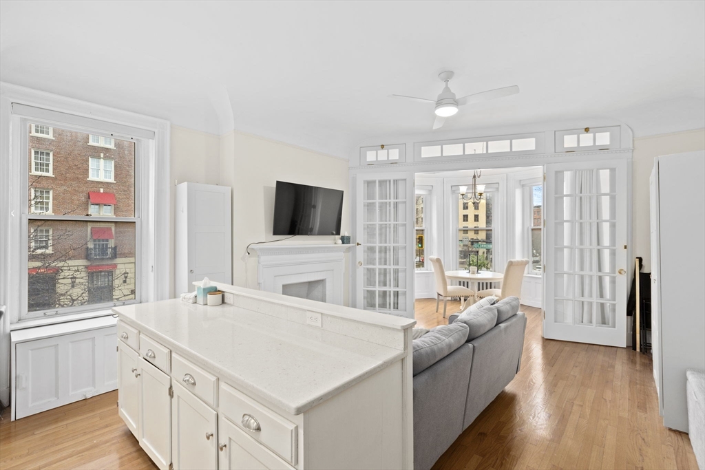 362 Commonwealth Avenue, Unit 2H Boston, MA 02115 - Photo 5 of 20 a living room with stainless steel appliances kitchen island granite countertop a couch and a flat screen tv