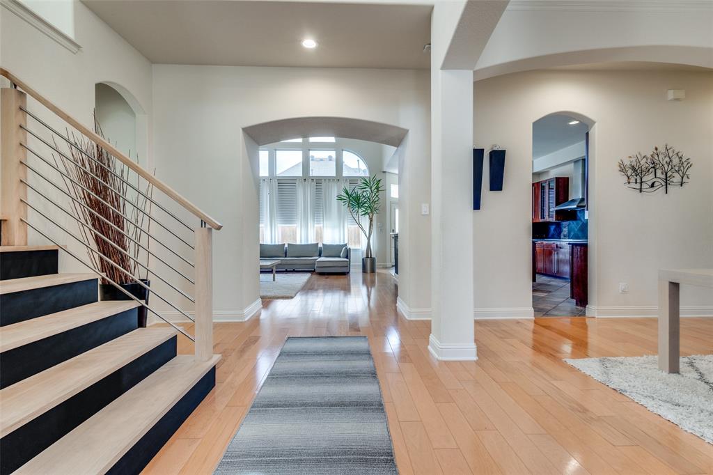 3313 Madison Avenue Hurst, TX 76054 - Photo 32 of 36 Entrance foyer with crown molding, light wood flooring, a towering ceiling, track contemporary lighting, and a chandelier