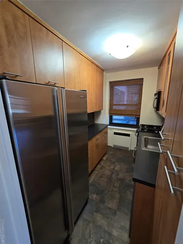 a kitchen with granite countertop stainless steel appliances a refrigerator and a counter