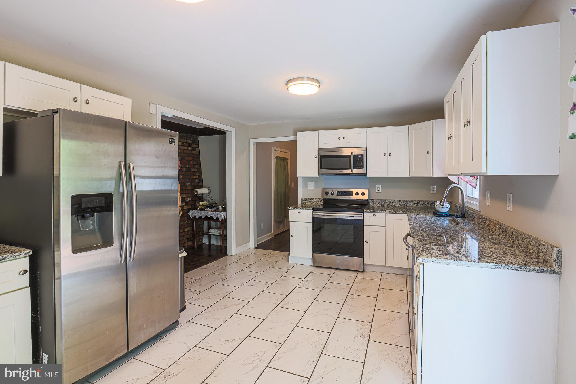 7933 34th Street Rosedale, MD 21237 - Photo 11 of 32 a kitchen with stainless steel appliances granite countertop a refrigerator sink and stove